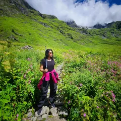 Exploring the Valley of Flowers in Uttarakhand. For trekking, I advise practical clothing like these track pants and a bright pink jacket for visibility and a pop of color against the green landscape.