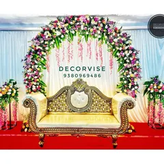For clients who prefer a comfortable sofa instead of a swing, we create elegant stage setups like this one. A grand floral arch made of roses and orchids frames the seating area, creating a perfect photo opportunity for the parents-to-be.