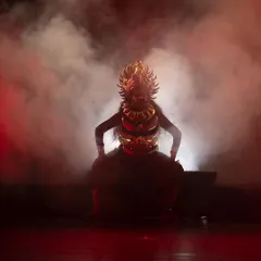 The dramatic entrance of a character from "KRISHNA", shrouded in smoke and powerful red light. We use these theatrical elements to build intensity and highlight pivotal moments in the narrative.