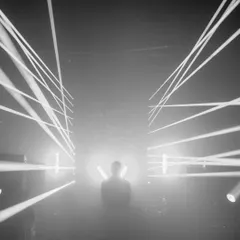 A moment of focus captured in black and white. The laser grid creates a cage of light, showing how I use lighting design to transform the physical space of a club.