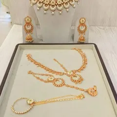 This beautiful gold-plated jewellery set includes a choker, earrings, maang tikka, and hathphool. It's the perfect rental to pair with a traditional lehenga.