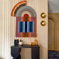 Wall art is a powerful tool for storytelling in a space. This colorful, abstract piece acts as a focal point in the lobby, introducing a palette of warm and cool tones that are echoed in other decor elements. It brings energy and a touch of bohemian charm to the entrance.