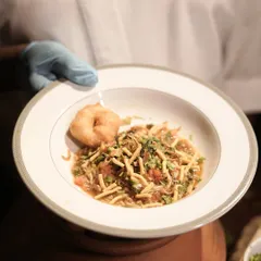Showcasing our culinary innovation, this is our Rassam Khow Suey. We've fused the tangy, spicy flavours of South Indian Rassam with the comforting format of Burmese Khow Suey for a truly unique fusion dish.