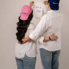 A fun and cute gender reveal. The "Best Mom" and "Best Dad" hats with the "It's a Boy" onesie are a sweet and personal touch for a casual shoot.