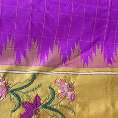 A close-up view of the Kamal Kadai embroidery on a Kanjeevaram silk saree's border. You can see the detail in the woven stitch that forms the flower petals, a technique that adds beautiful texture and dimension to the fabric.