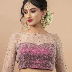 For moments that require extra sparkle, this party-wear blouse is a favorite. It features a delicate sweetheart neckline overlaid with a sheer, boat-neck layer, all meticulously hand-embroidered with beads. The full-length sheer sleeves add a touch of sophisticated glamour.
