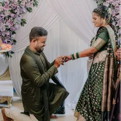 The moment of the proposal during a traditional engagement ceremony. The groom is on one knee, and the bride's smile says it all.