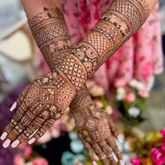 This is a classic full-coverage bridal mehendi, featuring incredibly detailed traditional patterns, including symbolic elephants and intricate geometric work extending up the forearms.