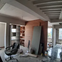 The early stages of an office interior project. This image shows the bare shell with the framework for custom shelving and ceiling details being put into place, the first step in transforming a blank canvas.