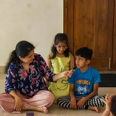 A teacher gently encourages a young boy to share his voice. My workshops are about creating a safe space where every child feels seen, heard, and confident enough to participate in their own way.
