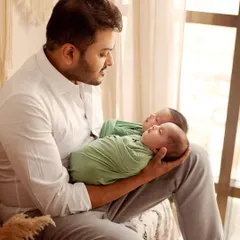 A father's love is so powerful. This quiet moment between a new dad and his sleeping twins during their newborn photoshoot is just beautiful. These are the portraits that become treasured family heirlooms.
