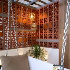We used terracotta jali screens to enclose this swing seating area. The perforated blocks provide a sense of privacy and create beautiful light patterns, making it a perfect spot for quiet relaxation.