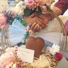 A romantic hamper designed for Promise Day, featuring a large, intricately patterned milk chocolate heart. The arrangement is complemented by flowers and smaller chocolates, creating a beautiful and heartfelt gift for your loved one.