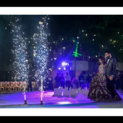 A grand reception entrance. The couple makes their way onto the dance floor surrounded by cold pyro sparklers, creating a dramatic and magical start to their celebration.