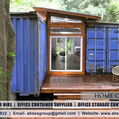 A creative home design using two blue containers connected by a central, modern living space with a glass facade. This project showcases how we integrate industrial elements with contemporary home design.