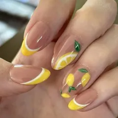 A fun and fruity summer design. This look features a negative space background with cheerful yellow French tips and hand-painted lemon art, perfect for a vacation.