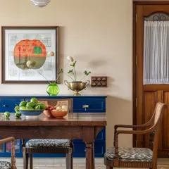 The dining area of the Calcutta home, where a bold blue console adds a pop of color. The space is a mix of vintage finds and modern pieces, reflecting a family that honors its past while living fully in the present.
