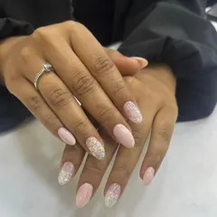 A soft and elegant almond-shaped nail set. The design features a delicate pink base with a sparkling glitter fade, creating a sophisticated and eye-catching look suitable for any occasion.