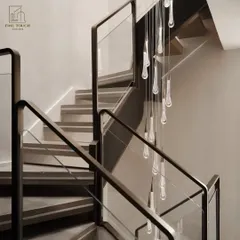 Detail is key in luxury design. This close-up shows a custom-designed staircase featuring clean lines, glass paneling, and a cascading teardrop chandelier that serves as a functional art piece within the home.