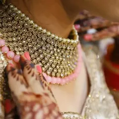 This is another angle of the bridal choker, capturing the craftsmanship and the way it complements the bride's attire and henna. These shots add an emotional connection to the product.