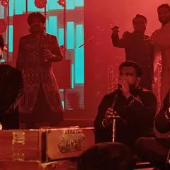The stage is set for a night of musical fusion. Here, talented qawwali singers and a full band come together to perform, showcasing the rich diversity of a live studio-style entertainment concept.