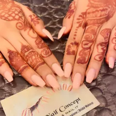 A simple and elegant choice for a bride. These coffin-shaped nails are painted in a soft, shimmery peach color that beautifully complements the detailed henna design.