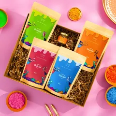 Another angle of the Holi gift box, this time on a bright pink background. This top-down shot clearly displays all the contents of the box in a fun and eye-catching way, perfect for social media announcements.