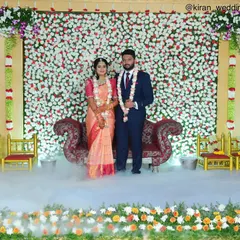 A classic reception look with a dense wall of white and red flowers. The fog effect on the floor adds a layer of romance to the couple's first appearance.