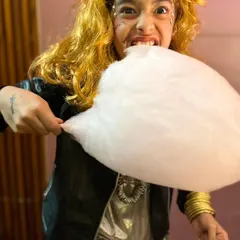 A ghostly rockstar takes a huge bite of pink cotton candy. Halloween is all about having fun and being silly!