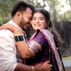 A candid shot filled with joy, showing the groom embracing his bride from behind. Her radiant smile captures the happiness of a Maharashtrian wedding ceremony.