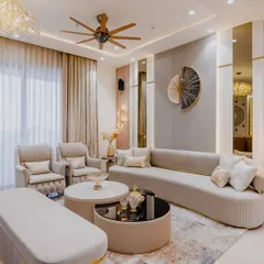 A closer look at the details that make this living room special. The combination of a curved sofa, armchairs, and a bench offers flexible seating, while the wall art and lighting act as focal points. This is a great example of a modern luxury interior design.