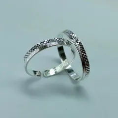 Another view of the classic etched silver toe rings, shown on a plain background to highlight their pattern.