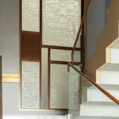 The main staircase at the Bammi Residence, featuring intricate Sanjhi screens by artist Vijay Kumar Verma at the landing. This detail showcases our approach of integrating traditional Indian crafts into functional architectural elements.