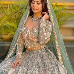 This pastel green lehenga with a pearl-encrusted blouse is a stunning choice for a daytime event or an evening reception. The sheer sleeves and detailed embroidery add a touch of modern sophistication.