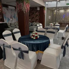 Another seating option with a dark blue velvet tablecloth and stylish grey velvet chair covers, perfect for a modern reception theme.