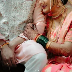 A close-up of the couple's hands, showing the intricate mehndi and the bride's traditional green bangles.