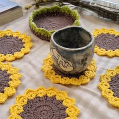 The full set of six sunflower coasters displayed with their handy storage basket. They are ready to bring a little sunshine to your tea time.