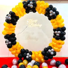 A striking black and yellow balloon ring with a 'Happy Birthday' neon sign. The balloons are arranged in flower-like clusters for a unique design.
