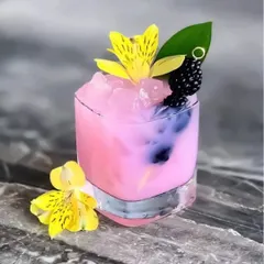 Our bar service is all about crafting beautiful drinks that taste as good as they look. This vibrant pink mocktail, garnished with fresh flowers and berries, is a perfect example of how we add a pop of colour and elegance to any celebration.