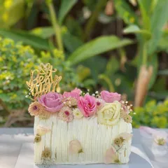 This beautiful Mango Cream Cheese log cake was made for a Mother's Day celebration. It features delicate piped frosting and is crowned with fresh pink and yellow roses.