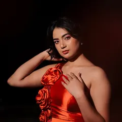 A bold studio portrait using dramatic lighting to make the red satin dress pop against the dark background. This style is perfect for creating a powerful, high-fashion statement.