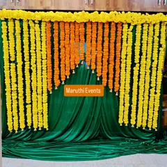 A classic and always beautiful backdrop made of dense yellow and orange marigold garlands. This traditional setup is perfect for Mehandi ceremonies, pujas, or any festive occasion, set against a rich green velvet drape.