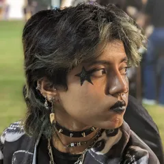 A cool, gothic-style look with a black star over the eye and black lipstick, perfect for a themed party.