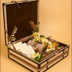 An open view of our signature wedding trousseau trunk, elegantly filled with gourmet jars, gift packets, and delicate floral arrangements. This is a perfect, luxurious gift for a bride-to-be.