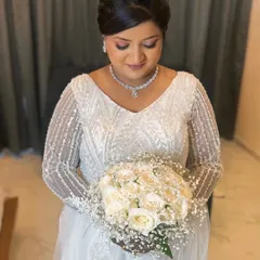 A close-up of the bride's makeup. The look features soft, shimmery eyeshadow, a natural lip color, and a flawless base, creating a classic and romantic bridal style.