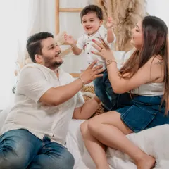 The pure joy of being together. This candid shot from a studio family session captures the happy energy and love between parents and their little boy.