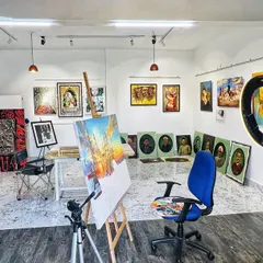 Another view of the studio, with an easel and painting in progress at the center. The space is organized to inspire creativity, with good lighting and my work surrounding me.