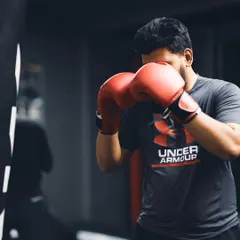 A fighter works the heavy bag, keeping his guard up and focusing on his form. The bag doesn't hit back, but it builds power and endurance.