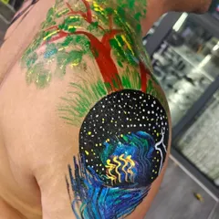 This intricate shoulder piece combines a starry night sky with a vibrant tree. In my workshops, I encourage participants to paint what they feel, resulting in unique and deeply personal works of art.