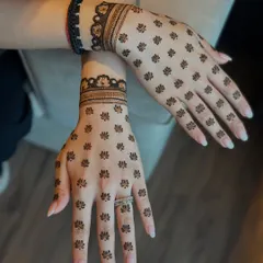 A very chic and minimal design with tiny lotus motifs scattered across the back of the hands, paired with a simple wristband.
